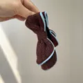 Detailed view of a textured tweed bow hair clip in brown with light blue trim held in hand. - Bow Banana Clip