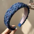 Close-up of navy blue chunky knit headband with colorful flecks and a wide brim design. - Knitted Headband / Blue