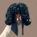 Detail van zwarte pailletten strik haarklem met glanzende textuur en elegant lintdetail. - Pailletten Strik Haarklem