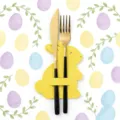 Detail shot of elegant gold cutlery in yellow rabbit felt holder for Easter table decor - Yellow
