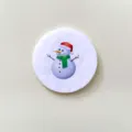 Close-up of a circular white badge featuring a cute cartoon snowman for Christmas gift. - Snowman