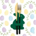 Close-up macro view of green felt bunny cutlery holder with gold and black fork and knife - Green
