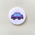 Macro detail view of a cute purple cartoon car badge on a soft white felt circle. - Car