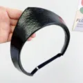 Detailed view of glossy black PU leather crown-shaped headband with adjustable strap - Adjustable Size / Black