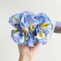 Detailed macro view of a large oil painting style scrunchie with vibrant blue and yellow hues - Scrunchie