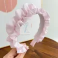 Gros plan d'un serre-tête en tulle rose froncé avec des détails de petits pois blancs. - Plissé à pois / Rose