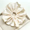 Gros plan d'un chouchou en satin crème élégant orné de magnifiques perles délicates - Chouchou Grandes Perles / Beige