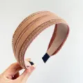 Macro detail view of a wide champagne pink headband embellished with rows of sparkling rhinestones. - Wide Side Style / Pink