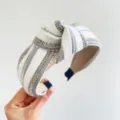 Dettaglio di fascia per capelli annodata bianca con strass luccicanti e treccia argentata. - Stile Annodato / Bianco