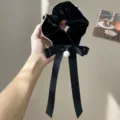 Close-up of black velvet scrunchie with large satin bow and pearl charm - Bow Pearl Ribbon Hair Tie