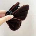 Gros plan d'une élégante pince à cheveux en velours marron foncé avec liseré - Style Papillon (S378) / Chocolat (Bord Café)