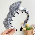 Close-up of a blue plaid rabbit ear headband with non-slip inner teeth for a secure fit. - Rabbit Ears Toothed Style / Black And Blue Plaid Rabbit Ears Toothed Headband