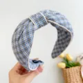 Detailansicht eines blau-weiß karierten Haarreifens mit elegantem Knotendesign. - Schwarz-Blau Kariert Mit Eingefasster Kante Haarband