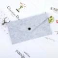 Detail view of the gray felt envelope storage bag featuring a secure black snap button - Gray