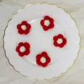 Detail van vijf rood-witte wolvilt bloemen voor verschillende doe-het-zelf projecten - 5 Stuks / Rood