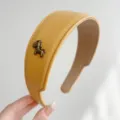 Detailansicht des gelben Leder-Haarreifens mit bronzenem Pferdeanhänger-Accessoire - Leder Pferd Stirnband / Gelb