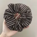 Detailed macro shot of a brown sequined scrunchie with white v-shaped embroidery patterns - Scrunchie / Coffee Sequins
