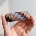 Gedetailleerd overzicht van vintage Fair Isle gebreide haarklem met gouden M-logo ruitpatroon. - Haarclip / Blauw Koffie Patchwork