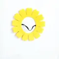 Detailed close-up view of a vibrant yellow felt sunflower prop with a black elastic strap. - Large Sunflower / Yellow