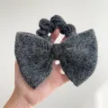 Détail d'un chouchou à nœud gris foncé avec une texture douce en laine de vison synthétique - Style Noeud Couleur Unie / Gris foncé