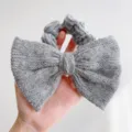 Gros plan d'un chouchou en maille de vison grise avec un grand nœud papillon ultra doux - Style Noeud Couleur Unie / Gris clair
