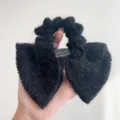 Gros plan sur un chouchou nœud en tricot noir avec étiquette 'Hand Made'. - Style Noeud Couleur Unie / Noir