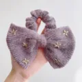 Detail van een zachte paarse nertswol strik scrunchie met gouden ster bedeltjes voor haar - Vijfpuntige Ster Stijl / Taropaars