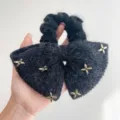 Detailweergave van zwarte nertswollen strik-haarscrunchie met gouden sterversieringen - Vijfpuntige Ster Stijl / Zwart