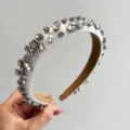 Detailaufnahme eines weißen gepolsterten Stirnbands mit funkelndem klarem Strassbesatz. - Strass Dünnes Stirnband / Weiß