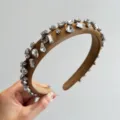 Detailaufnahme von funkelnden Kristallen auf einem gepolsterten braunen Stirnband - Strass Dünnes Stirnband / Hellkamel