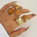 Close-up detail of vintage gold rings set with orange acrylic stones worn on a hand - Luxury Vintage Gold Wrinkled Ring Set (6690401HB)