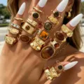 Primer plano de conjunto de anillos dorados bohemios con piedras ojo de tigre en la mano - Juego de Anillos Abiertos de Girasol Ojo de Tigre (6736001HB)
