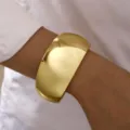 Elegante brazalete dorado ancho con efecto espejo, acabado pulido y diseño abierto sencillo - Estilo de Espejo Dorado en Forma de Tambor (6630601HB)