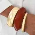 Conjunto de brazaletes gruesos de metal dorado y acrílico marrón rojizo en la muñeca - Juego de 3 Brazaletes Anchos de Espejo Dorado y Resina Ondulada Ámbar (6628701HB) / Juego de 3 / Dorado