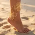 Detail view of a gold filigree flower anklet worn on a beach, showing 3D hollow petals. - Stereoscopic Hollow Flower Style (6743901HB) / Gold