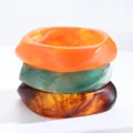 Vista de primer plano de tres brazaletes de acrílico irregulares apilados en naranja y verde. - Estilo Ámbar Verde Naranja Irregular de 3 Piezas (6705301HB)