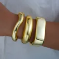 Juego de tres brazaletes gruesos en tono dorado con acabado espejo y diseño ondulado - Estilo de Onda y Arco de 3 Piezas (6579701HB)