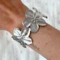 Brazalete de flores plateadas con acabado metálico pulido de espejo puesto en la muñeca - Brazalete Abierto de Flores Plateadas (6464902HB)