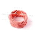 Detail view of a thick pink seamless elastic hair ring with a woven lattice texture. - Hollow Pink