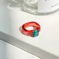Schicker transparenter roter Harz-Ring mit einem quadratischen grünen Edelstein - Einheitsgröße / Roter Smaragd-Stil (5303107)