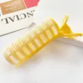 Detail shot of a yellow root volumizing hair clip with hook and loop texture. - Yellow (3790)