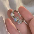 Elegante anello aperto in argento con tre pietre di luna iridescenti e texture lavica - Anello Cangiante a Consistenza Irregolare (5675802)
