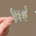 Funkelnde Strass-Schmetterlingsspange mit beweglichen Flügeln in Goldoptik und grünen Steinen - Grün (3301-2)