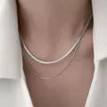 Elegant double-layered silver snake chain necklace worn by model in a white shirt jacket - Double Layer Snake Style (5547401HB) / Silver