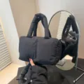 Stylish black quilted nylon puffer tote bag with padded handles and crossbody strap - Black