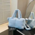 Lichtblauwe gewatteerde nylon schoudertas met dubbele handgrepen en crossbody-riem - Blauw