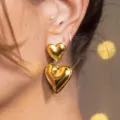 Elegant double-layered golden heart drop earrings with minimalist designer aesthetic - Gold Double Layer Heart (5845601)