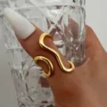 Minimalist irregular gold wavy open ring for women, styled on hand with glass cup - Wavy Line Open Ring (6464801)
