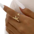 Elegant gold open ring featuring dual starfish charms worn on a person's finger - Double Starfish Style (6509401) / Gold