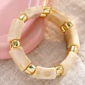 Elegante pulsera de resina acrílica jaspeada crema con espaciadores dorados brillantes. - Brazalete de Cuentas de Acrílico (6808002)
